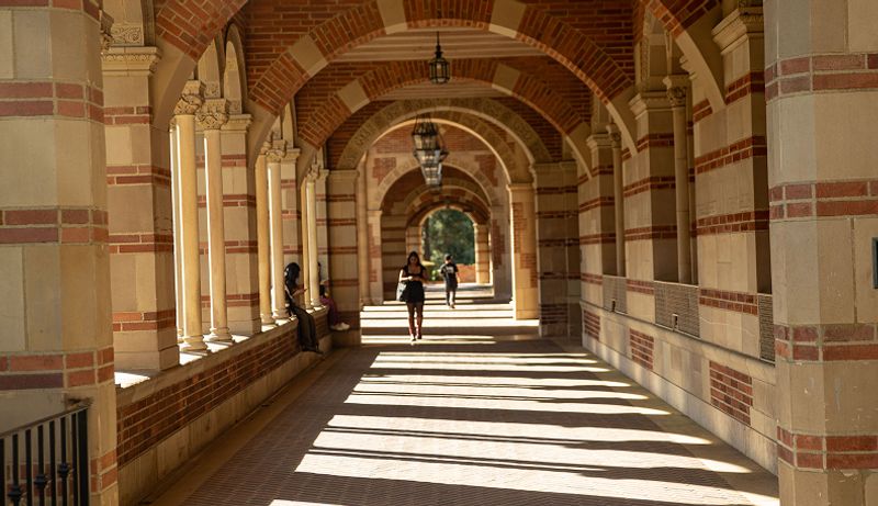 The sun shines through the Royce hall arches