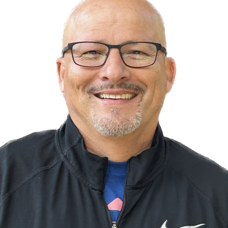 Headshot of bald Latino man with goatee wearing a blue Nike track suit
